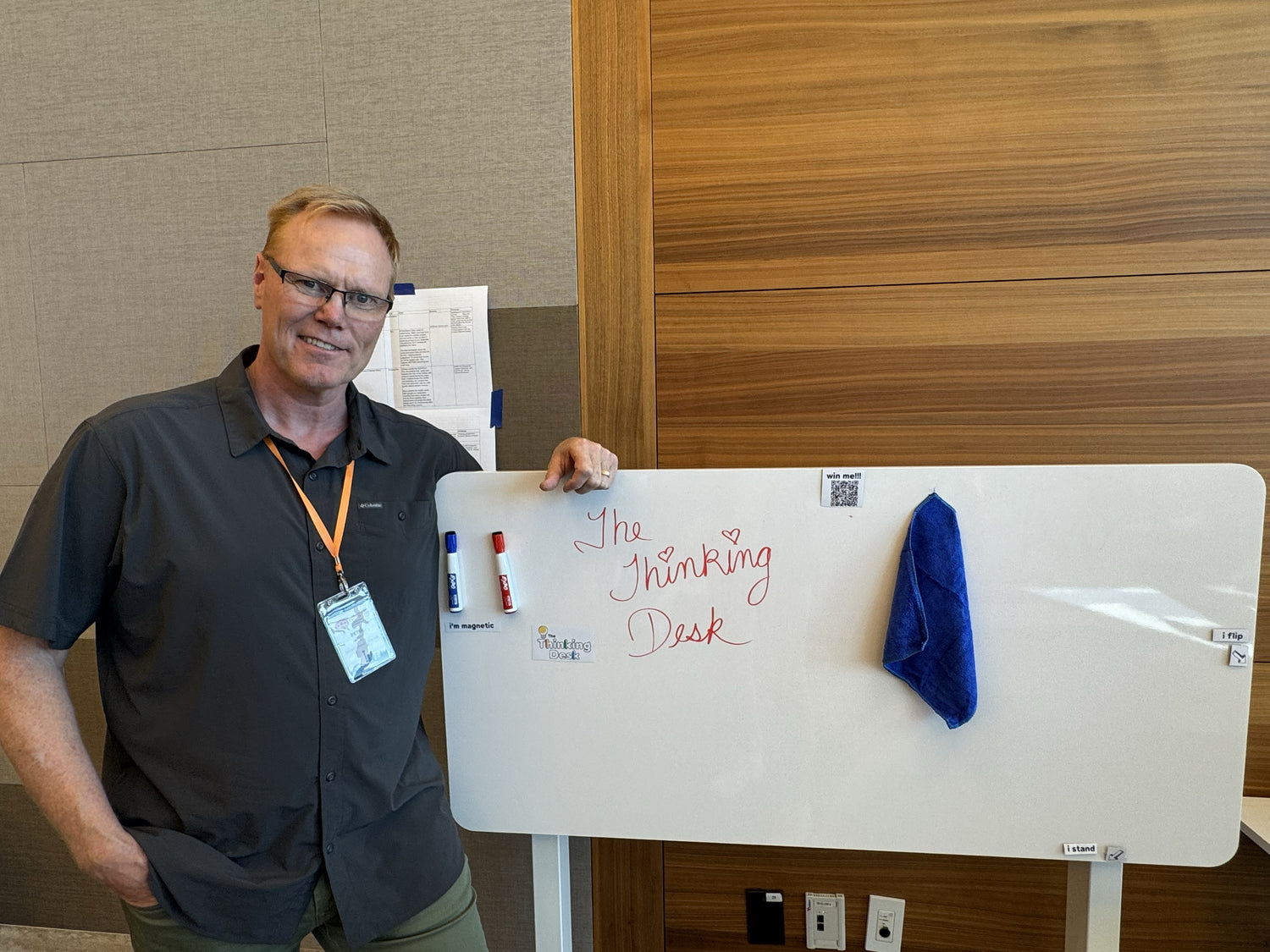 A man standing next to a whiteboard with 'The Thinking Desk.' 